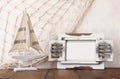 Old vintage wooden white frame and sailing boat on wooden table. vintage filtered image. nautical lifestyle concept Royalty Free Stock Photo