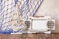 Old vintage wooden white frame and sailing boat on wooden table. vintage filtered image. nautical lifestyle concept Royalty Free Stock Photo