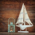 Old vintage wooden white sailing boat and lantern on wooden table. vintage filtered image. nautical lifestyle concept Royalty Free Stock Photo
