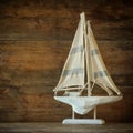 Old vintage wooden white sailing boat on wooden table. vintage filtered image. nautical lifestyle concept Royalty Free Stock Photo