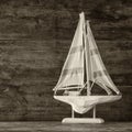 Old vintage wooden white sailing boat on wooden table. vintage filtered image. nautical lifestyle concept Royalty Free Stock Photo