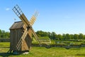 Old vintage wooden windmill in the background of the summer field. Saaremaa, Estonia. Royalty Free Stock Photo