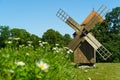 Old vintage wooden windmill in the background of the summer field. Saaremaa, Estonia. Royalty Free Stock Photo