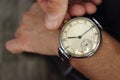 Old vintage wristwatch on men`s hand closeup. Time and deadline concept. Business and alarm background. Big retro watch.