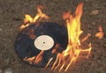 The old vinyl black plate burns on a stone surface Royalty Free Stock Photo