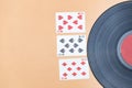 An old vinyl record and lucky three eights in cards