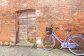 Old violet bicycle parked long an external wall in Burano island Royalty Free Stock Photo