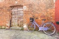 Old violet bicycle parked long an external wall in Burano island Royalty Free Stock Photo