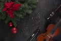Old violin, fiddlestick and flute with fir-tree branches with Christmas decor and poinsettia. Christmas and New Year`s concept. Royalty Free Stock Photo