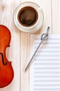 Old violin, pencil treble clef shape, musik note paper and cup of coffee.. Top view, close up, flat lay on white wooden background Royalty Free Stock Photo