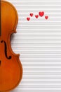 Old violin and red heart figurines. Top view, close up, flat lay on white music paper background Royalty Free Stock Photo