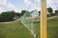 Old volleyball net in the village. Games for poor children outdoors. Summer sport field near the forest Royalty Free Stock Photo