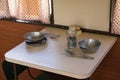 Old wagon interior. Train compartment, table, soup, spoon, glass. Railway road environment background.