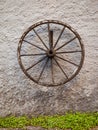 An old wagon wheel displayed on a rustic old wall Royalty Free Stock Photo