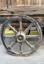 Old wagon wheel side by wooden wall Royalty Free Stock Photo