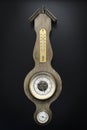 Old wall barometer with built-in hygrometer and thermometer. Black background Royalty Free Stock Photo