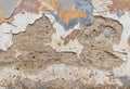 Old wall with crumbling plaster and peeling off paint