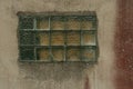 Old wall with glass block window. Translucent square glass tiles. Rough ribbed surface of green glass of window. Vintage texture