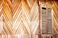 An old wall made of wooden slats with vintage carved shutters