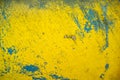 Old wall with scratched peeling blue-yellow paint. Abstract textured background. Copy space. Royalty Free Stock Photo