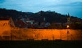The old wall that surrounds the old Brasov City. Black Church in the background. Blue hour image.