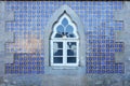 Old wall with traditional Portuguese decor tiles azulezhu in blue,yellow and brown tones with an old window as background. Royalty Free Stock Photo