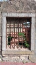 An old wall in which there is a window with a lattice sealed with bricks Royalty Free Stock Photo