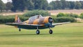 A Vintage North American Harvard aircraft lands on a grass airfield Royalty Free Stock Photo