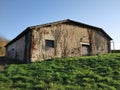 Old ware house in a green grass meadow on a cold winter noon Royalty Free Stock Photo