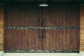 Old warehouse as dark brwon wooden sliding door with brown brick wall Royalty Free Stock Photo