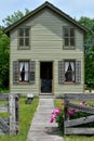 Green Irish House with Pink Peonies Blooming by Fence Royalty Free Stock Photo