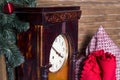 Old watch in a wooden box against the background of a red plaid and a multi-colored pillow, stands near a New Year tree