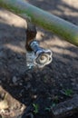 An old water faucet on a green metal pipe. The tap is vertical Royalty Free Stock Photo