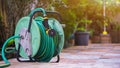 Gardening water hose roll up with nozzle on tile floor in home gardening area Royalty Free Stock Photo