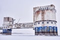 Old water intake station on a frozen river covered in snow and ice. abandoned landscape Royalty Free Stock Photo