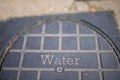 Old water manhole cover with a square pattern Royalty Free Stock Photo