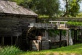 Old water mill made of wood with a wheel rotating from the flow of water Royalty Free Stock Photo