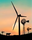 An old water pumping windmill stands in contrast to the giant energy producing wind turbine