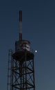 Old water tank with antenna and graffiti in front of the moon Royalty Free Stock Photo