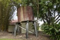 An Old Water Tank On Leaning Wooden Posts Royalty Free Stock Photo