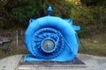 Old water turbine generator in blue spiral casing Royalty Free Stock Photo