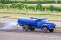 An old water truck is moistening a dirt road by removing dust Royalty Free Stock Photo