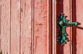 old weather-beaten red door with old vintage door knob, surface with chapped textured paint Royalty Free Stock Photo