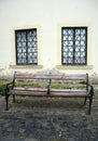 Old weathered bench with two windows behind on a street Royalty Free Stock Photo