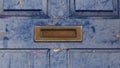 Old weathered brass letterbox on old blue grunge front door Royalty Free Stock Photo