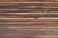 Old, weathered, brown wood planking of a facade with narrow wooden strips