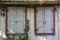 Old weathered closed wooden shutters in an abandoned house