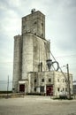 Old Weathered Concrete Grain Elevator with Worn Red Doors
