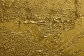 Golden weathered peeling cracked glossy graffiti paint on wall. Background of gold color Royalty Free Stock Photo