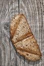 Toasted Slice Of Dark Bread Set On Rustic Old Knotted Cracked Rough Pinewood Table Surface